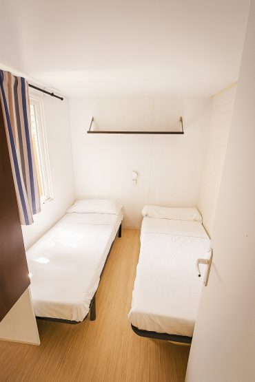 Interior de bungalow en Camping MOLA! Surf Loredo con cama doble y luz natural